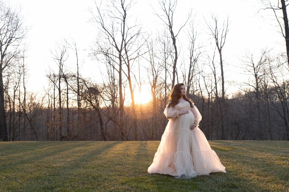 Maternity portrait in a flowing cream gown at sunset in a Maryland field by Create With Amy