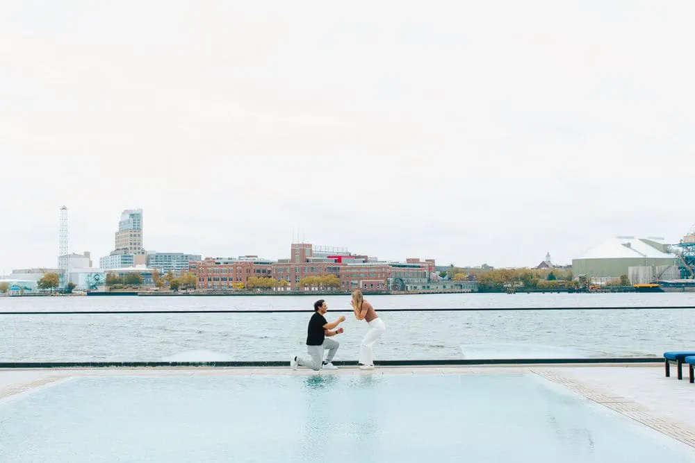 Surprise proposal on one knee beside a waterfront pool, captured by Create With Amy, Baltimore proposal photographer