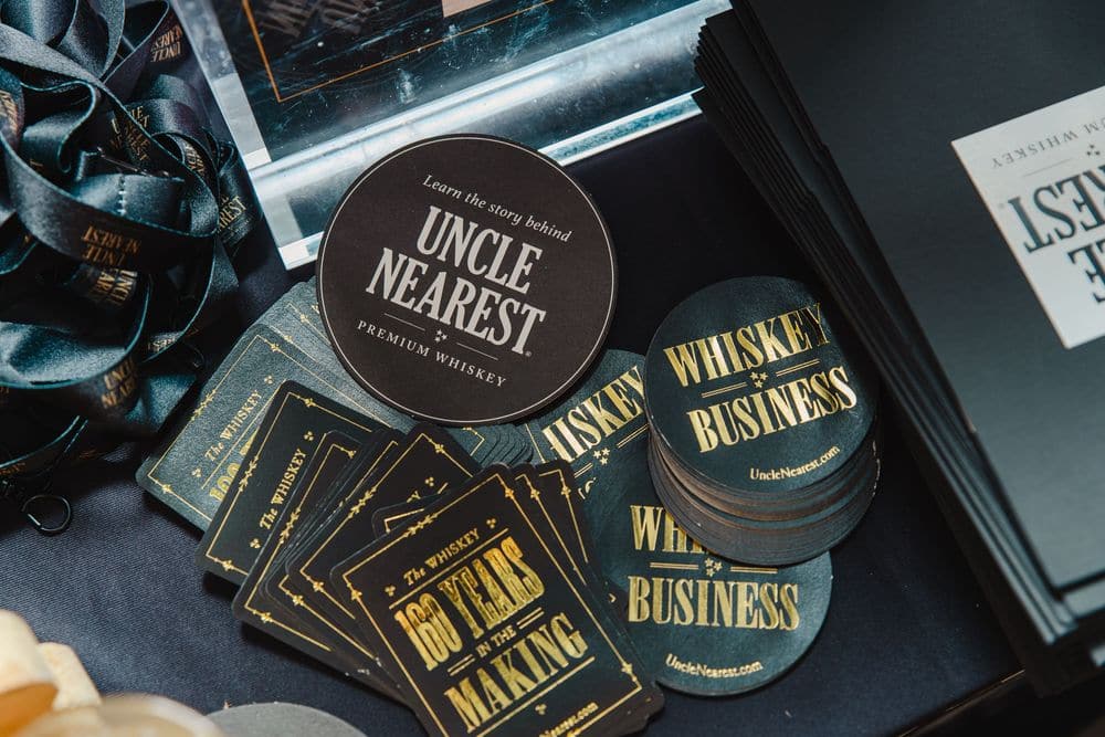Branded coasters and event details from a TEOS whiskey event covered by Create With Amy for social media content